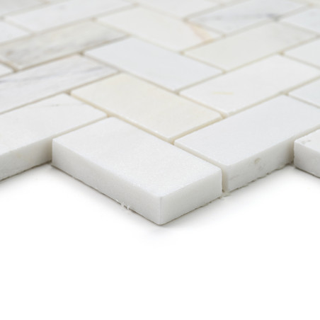Rectangular stone tiles lie flat, forming an overlapping grid pattern. they are smooth with a polished, off-white surface.