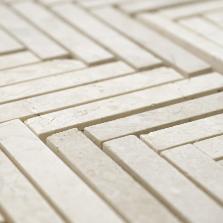 Les carreaux de pierre rectangulaires forment un motif géométrique imbriqué sur une surface plane, créant une mosaïque texturée 
