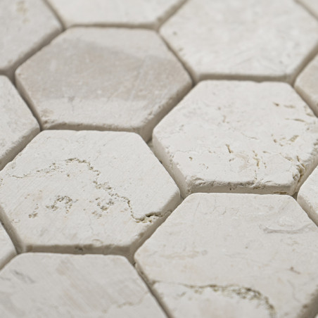 Les carreaux de pierre hexagonaux forment un motif texturé, avec des surfaces blanches rugueuses et de subtiles veines grises, é