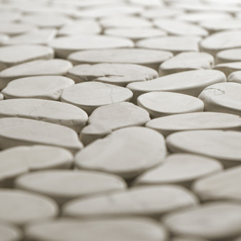 Glatte, ovale Steinfliesen passen eng aneinander und schaffen eine nahtlose Oberfläche in einer sanft beleuchteten Umgebung.