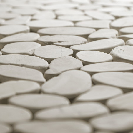 Les carreaux de pierre lisses et ovales s'emboîtent étroitement, créant une surface homogène dans un environnement doucement écl Les carreaux de pierre lisses et ovales s'emboîtent étroitement, créant une surface homogène dans un environnement doucement écl