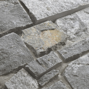 Les carreaux de pierre grise brute s'emboîtent, formant une surface texturée. fixé dans un coulis léger pour un aspect terreux e