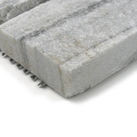 Les carreaux de pierre grise brute présentent une texture mouchetée, reposant sur une surface blanche, mettant en valeur des mot