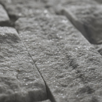 Les carreaux de pierre bruts et rectangulaires réfléchissent la lumière, créant un effet scintillant en vue rapprochée, posés se