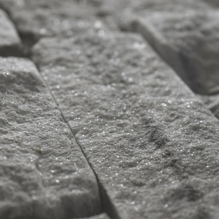 Raue, rechteckige Steinfliesen reflektieren das Licht und erzeugen bei näherer Betrachtung einen funkelnden Effekt, verlegt in e