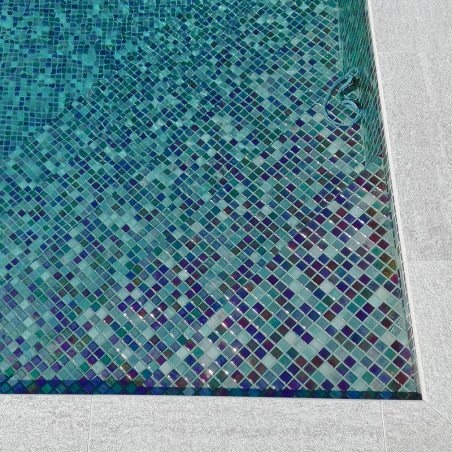 Mosaicos azuis e verdes criam um padrão complexo, revestindo o fundo de uma piscina retangular.