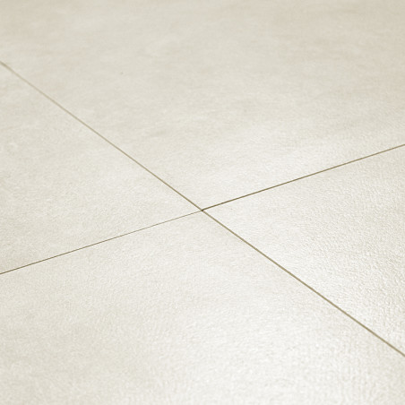 Les carreaux de céramique beiges forment un motif de grille, relié par de fines lignes de coulis, créant une surface de sol liss