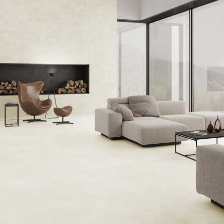 Un salon moderne comprend un grand canapé sectionnel beige faisant face à une élégante cheminée noire, avec des bûches empilées 