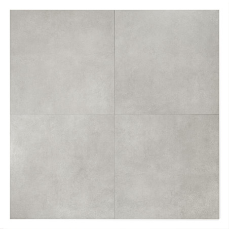 Quatre carreaux gris mat forment un carré, aligné avec de subtiles lignes de couture, dans un décor neutre.