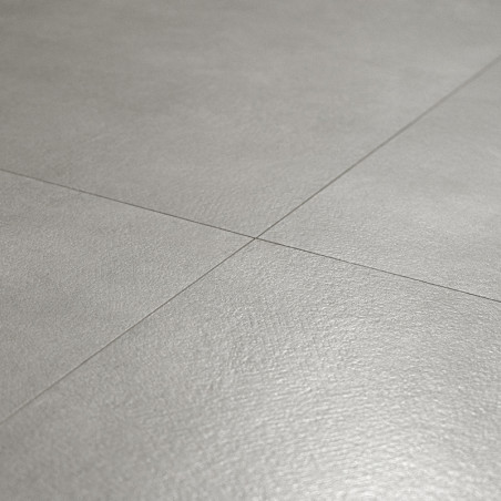Les carreaux de sol gris forment un motif lisse et homogène, se croisant à angle droit, dans une pièce minimaliste.