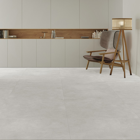 Une chambre minimaliste présente de grands carreaux de sol gris clair. Une chaise en bois avec des coussins et un lampadaire rep