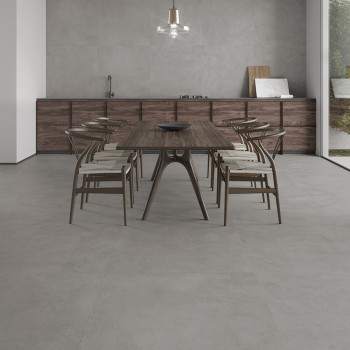 A wooden dining table with chairs stands on a smooth, light gray tile floor in a modern kitchen with minimalist decor.