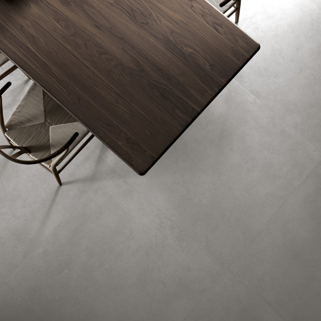 A dark wooden table sits atop a light gray, smooth tiled floor, surrounded by beige fabric chairs, creating a modern dining ambi