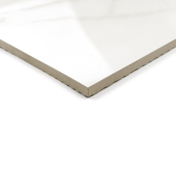 A white ceramic tile with a glossy finish and beveled edge lies on a white background, reflecting natural light from above.