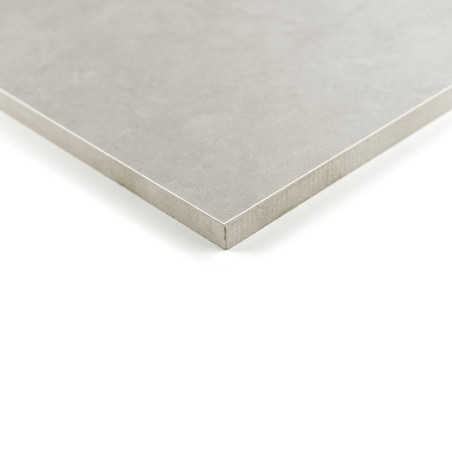 Un carreau carré gris mat repose sur une surface blanche, ses bords nets définissant un design épuré et minimaliste.