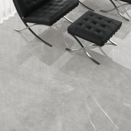 Sillas de cuero negro con capitoné descansan sobre azulejos con motivos de mármol de color gris claro. la habitación parece mode
