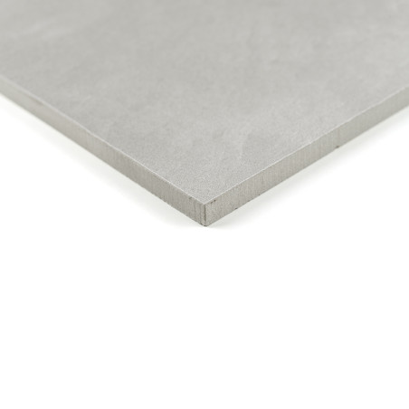 Um ladrilho quadrado, liso e cinza repousa sobre um fundo branco, exibindo sua borda nítida e limpa em um ambiente minimalista.