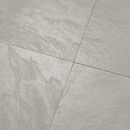 O ladrilho exibe uma superfície lisa e cinza claro com padrões de textura sutis, formando uma grade limpa em um piso bem revesti