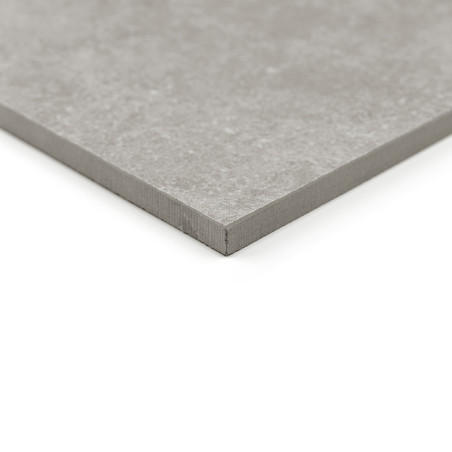 Un carreau carré gris repose en angle sur un fond blanc, mettant en valeur sa surface texturée et ses bords nets et nets.