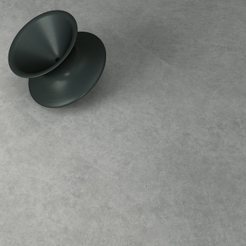 Un tabouret conique sombre repose en diagonale sur une surface de pierre lisse et gris clair, suggérant un espace intérieur à l'