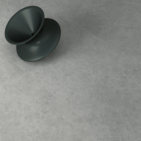 Un tabouret conique sombre repose en diagonale sur une surface de pierre lisse et gris clair, suggérant un espace intérieur à l'