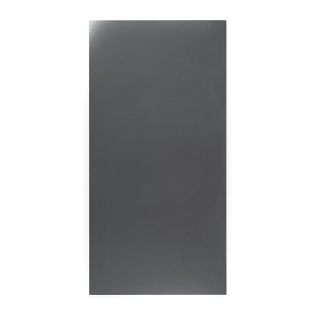 Un carreau gris rectangulaire reste immobile, présentant une finition mate lisse, sur un fond blanc uniforme et neutre.