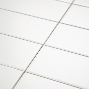 Los azulejos de cerámica blanca están dispuestas uniformemente en un patrón de cuadrícula, creando una superficie limpia y sin c