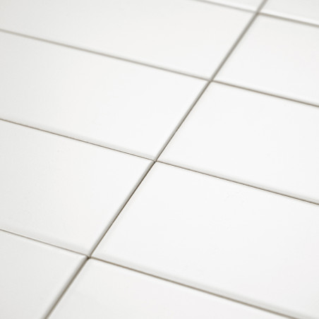 Les carreaux de céramique blanche sont disposés uniformément selon un motif en grille, créant une surface propre et homogène ave Les carreaux de céramique blanche sont disposés uniformément selon un motif en grille, créant une surface propre et homogène ave