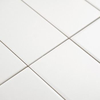 Weiße rechteckige Fliesen sind in einem Gittermuster angeordnet und bilden eine nahtlose und saubere Oberfläche in einer minimal