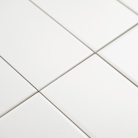 Witte rechthoekige tegels zijn uitgelijnd in een rasterpatroon en vormen een naadloos en strak oppervlak in een minimalistische 