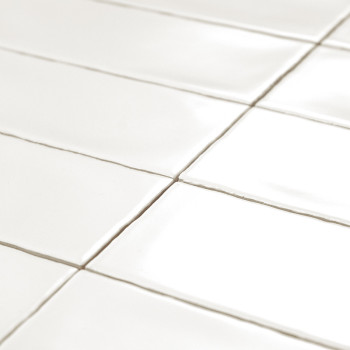 Les carreaux rectangulaires blancs brillants sont soigneusement disposés selon un motif en grille, réfléchissant la lumière. le 