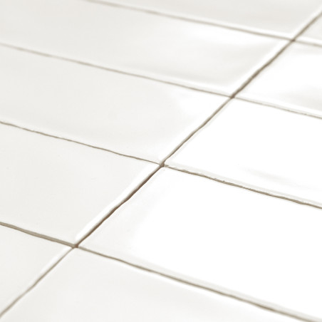 Los azulejos rectangulares de color blanco brillante están cuidadosamente dispuestos en forma de cuadrícula, reflejando la luz. 