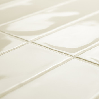 Ladrilhos retangulares brancos brilhantes formam um padrão de grade, refletindo a luz em uma sala espaçosa, com linhas de argama