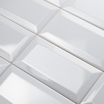 azulejos rectangulares blancas dispuestas en cuadrícula, con una superficie brillante y biselada que refleja la luz en un patrón