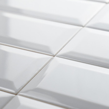 Los azulejos rectangulares blancos y brillantes están cuidadosamente dispuestos en un patrón de cuadrícula, creando una superfic