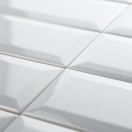 Los azulejos rectangulares blancos y brillantes están cuidadosamente dispuestos en un patrón de cuadrícula, creando una superfic