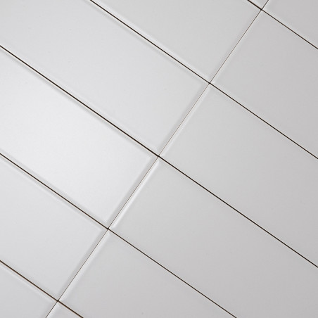 Witte rechthoekige tegels diagonaal uitgelijnd, waardoor een rasterpatroon ontstaat. Donkere voegenlijnen scheiden de tegels en Witte rechthoekige tegels diagonaal uitgelijnd, waardoor een rasterpatroon ontstaat. Donkere voegenlijnen scheiden de tegels en