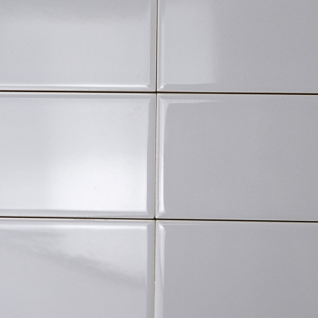 White rectangular tiles are aligned in a grid pattern, creating a smooth, glossy surface under soft lighting in a minimalist set