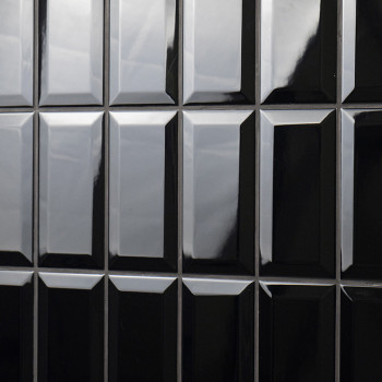 Los azulejos rectangulares de color negro brillante están dispuestos en forma de cuadrícula. reflejan la luz, creando una aparie