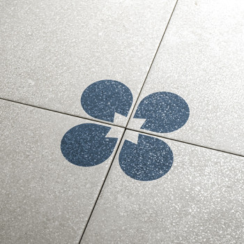 Cuatro mosaicos de color gris claro, cada uno con un cuarto de círculo azul oscuro con una muesca, forman un patrón circular com