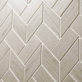 Les carreaux beiges disposés selon un motif à chevrons forment une surface texturée, créant un motif géométrique avec des nuance
