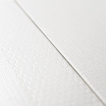 Twee witte getextureerde tegels met subtiele patronen ontmoeten elkaar in een naad, waardoor een minimalistisch ontwerp ontstaat