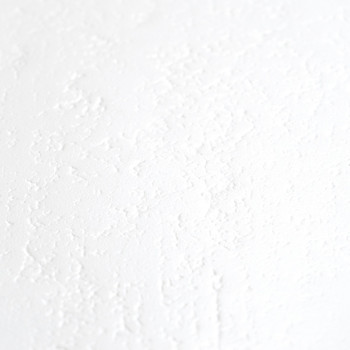 Um ladrilho branco com uma superfície sutil e texturizada, lembrando um leve acabamento em gesso ou estuque, é posicionado contr