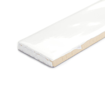 Um ladrilho retangular com acabamento branco brilhante fica em pé sobre um fundo branco, destacando sua superfície lisa e bordas