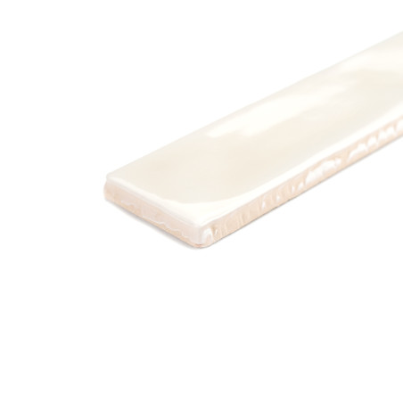 Un azulejo cerámico rectangular de color blanco brillante descansa sobre una superficie blanca lisa, resaltando su textura suave