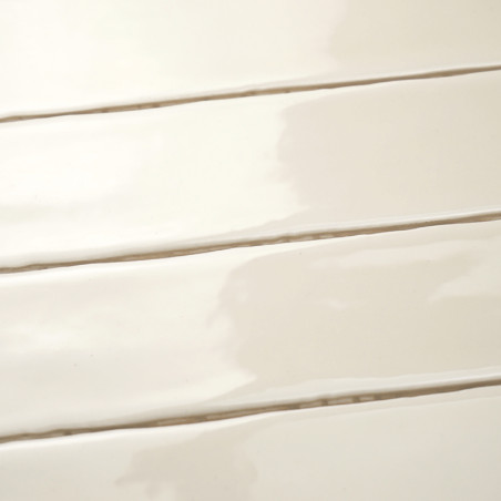 Los azulejos rectangulares brillantes están alineados horizontalmente, creando una superficie elegante y lisa. El color suave y 