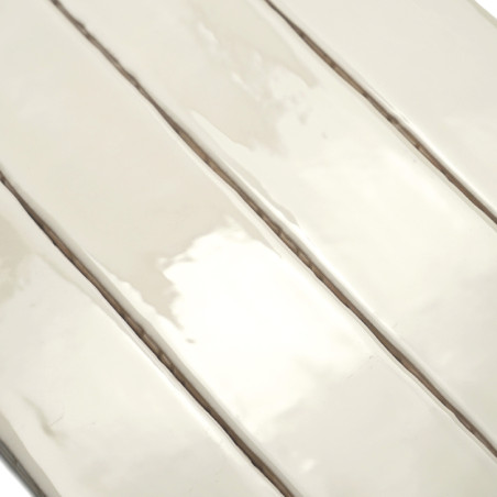 Quatro ladrilhos retangulares alongados e brilhantes estão alinhados lado a lado, refletindo a luz. A superfície cerâmica lisa s