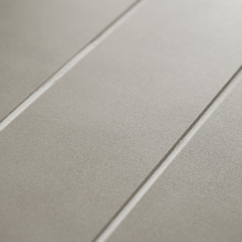Graue Keramikfliesen weisen eine matte Oberfläche auf und werden von zwei parallelen Fugenlinien durchzogen, was ein minimalisti