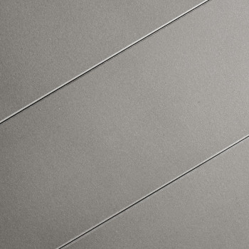 Les carreaux gris comportent trois rainures diagonales parallèles. La surface lisse et mate suggère un design moderne et minimal