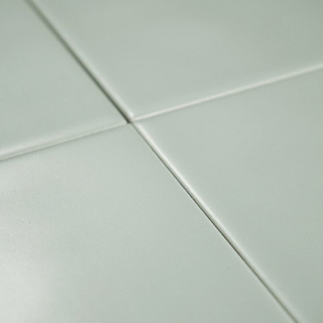 Vier hellgrüne Fliesen treffen an den Ecken in einem Gittermuster aufeinander und bilden eine glatte, saubere Oberfläche mit dez Vier hellgrüne Fliesen treffen an den Ecken in einem Gittermuster aufeinander und bilden eine glatte, saubere Oberfläche mit dez